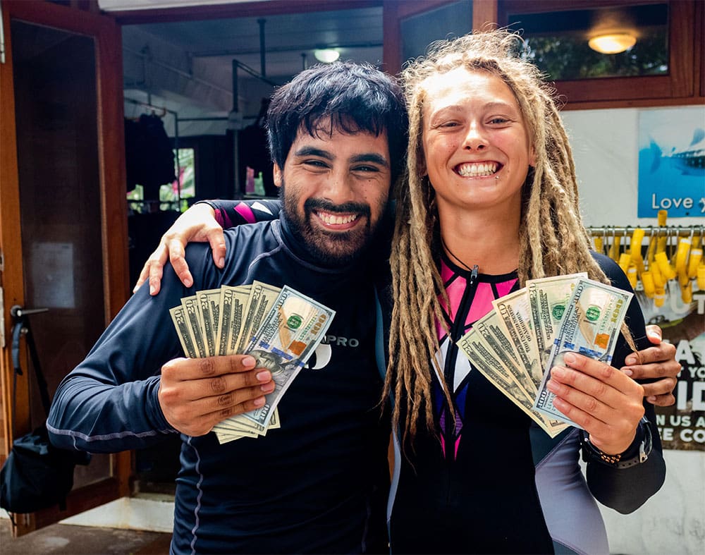 Two dive professionals holding cash after working in the scuba diving industry